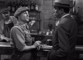 Movie still from “Hotel du Nord” (1938), directed by Marcel Carné – A man in a hat talking to another man in a hat; Medium shot, High angle