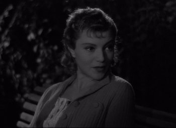 Movie still from “Hotel du Nord” (1938), directed by Marcel Carné – A black - and - white photo of a woman sitting on a park bench; Close Up shot, High angle