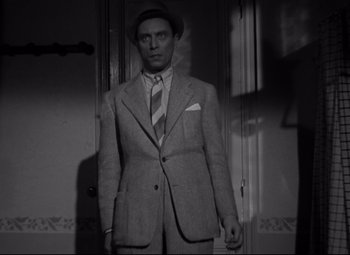 Movie still from “Hotel du Nord” (1938), directed by Marcel Carné – A black and white photo of a man in a suit and tie; Medium shot, Low angle