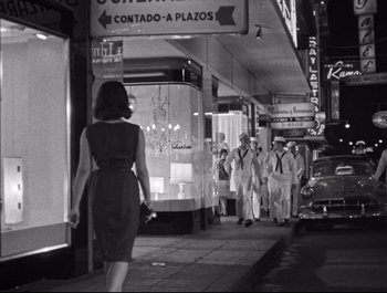 A group of people walking down a street at night