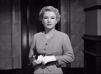 Movie still from “I Confess” (1953), directed by Alfred Hitchcock – An old photo of a woman holding a pair of scissors; Medium shot, Low angle