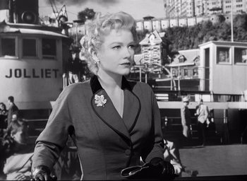 Movie still from “I Confess” (1953), directed by Alfred Hitchcock – An old black and white photo of a woman; Medium shot, Low angle