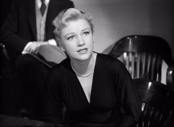 Movie still from “I Confess” (1953), directed by Alfred Hitchcock – An old photo of a woman sitting in a chair; Medium shot, Low angle