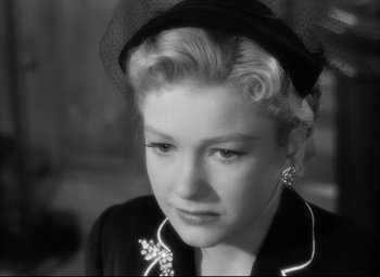 Movie still from “I Confess” (1953), directed by Alfred Hitchcock – An old photo of a woman wearing a black hat; Close Up shot, Over the shoulder angle