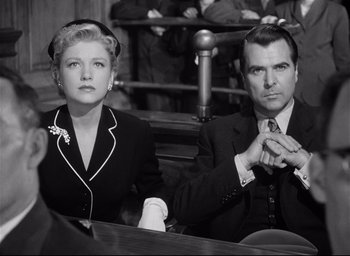 Movie still from “I Confess” (1953), directed by Alfred Hitchcock – A man and a woman sitting in front of each other; Medium shot, High angle