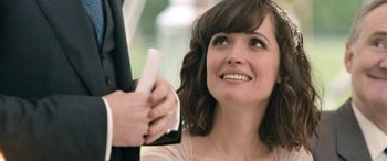 Movie still from “I Give It a Year” (2013), directed by Dan Mazer – A person holding something; Close Up shot, Over the shoulder angle