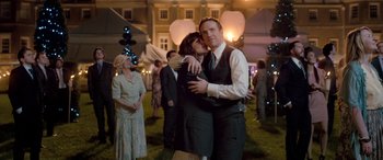 Movie still from “I Give It a Year” (2013), directed by Dan Mazer – A man and a woman hugging each other in front of a crowd; Medium shot, Over the shoulder angle