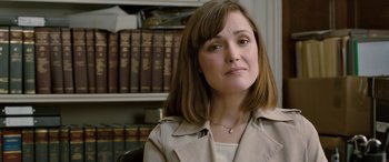 Movie still from “I Give It a Year” (2013), directed by Dan Mazer – A person sitting in front of a bookshelf; Close Up shot, Over the shoulder angle