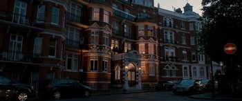 Movie still from “I Give It a Year” (2013), directed by Dan Mazer – A building that is lit up at night time; Extreme Wide shot, Low angle