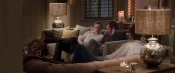 Movie still from “I Give It a Year” (2013), directed by Dan Mazer – Two men are sitting on a couch and talking; Wide shot, Over the shoulder angle