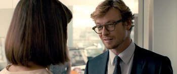 Movie still from “I Give It a Year” (2013), directed by Dan Mazer – A man in a suit and glasses talking to a woman; Close Up shot, Over the shoulder angle