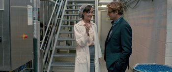 Movie still from “I Give It a Year” (2013), directed by Dan Mazer – A woman in a lab coat talking to a man in a suit; Medium shot, Over the shoulder angle