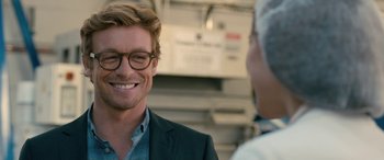 Movie still from “I Give It a Year” (2013), directed by Dan Mazer – A person wearing glasses and a suit; Close Up shot, Over the shoulder angle