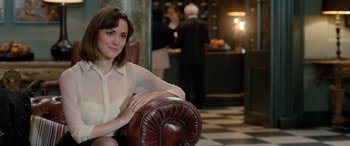 Movie still from “I Give It a Year” (2013), directed by Dan Mazer – A woman sitting in a chair in front of a bar; Medium shot, Over the shoulder angle