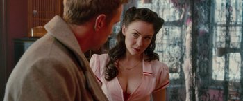 Movie still from “I Give It a Year” (2013), directed by Dan Mazer – A woman in a pink shirt is looking at a man in a brown suit; Close Up shot, Over the shoulder angle