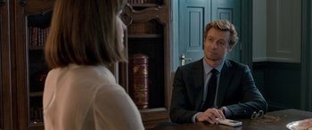 Movie still from “I Give It a Year” (2013), directed by Dan Mazer – A man and a woman sitting in front of a desk; Medium shot, Over the shoulder angle