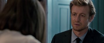 Movie still from “I Give It a Year” (2013), directed by Dan Mazer – A man wearing a suit and tie in front of a mirror; Close Up shot, Over the shoulder angle