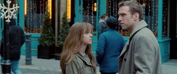 Movie still from “I Give It a Year” (2013), directed by Dan Mazer – A woman standing next to a man on the sidewalk; Close Up shot, Over the shoulder angle