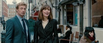 Movie still from “I Give It a Year” (2013), directed by Dan Mazer – A woman walking down the street wearing a black coat; Medium shot, Over the shoulder angle