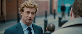 Movie still from “I Give It a Year” (2013), directed by Dan Mazer – A person wearing a suit and tie; Close Up shot, Over the shoulder angle