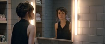 Movie still from “I Give It a Year” (2013), directed by Dan Mazer – A woman looking in the mirror in a bathroom; Close Up shot, Over the shoulder angle