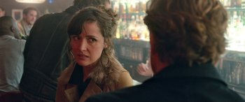 Movie still from “I Give It a Year” (2013), directed by Dan Mazer – A woman is sitting in front of a man in front of a bar; Close Up shot, Over the shoulder angle