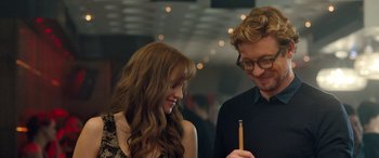 Movie still from “I Give It a Year” (2013), directed by Dan Mazer – A man and a woman looking at each other with a pencil; Close Up shot, Over the shoulder angle