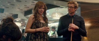 Movie still from “I Give It a Year” (2013), directed by Dan Mazer – A woman standing next to a man holding a drink; Medium shot, Over the shoulder angle