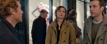 Movie still from “I Give It a Year” (2013), directed by Dan Mazer – A woman standing in front of a man in front of a store; Medium shot, Over the shoulder angle