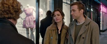 Movie still from “I Give It a Year” (2013), directed by Dan Mazer – A man and a woman standing next to each other in front of a store window; Medium shot, Over the shoulder angle