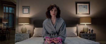 Movie still from “I Give It a Year” (2013), directed by Dan Mazer – A woman sitting on top of a bed in a robe; Medium shot, Overhead angle
