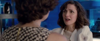 Movie still from “I Give It a Year” (2013), directed by Dan Mazer – A woman talking to another woman in front of a blue background; Close Up shot, Over the shoulder angle