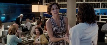 Movie still from “I Give It a Year” (2013), directed by Dan Mazer – A woman standing in front of a group of people in a restaurant; Medium shot, Over the shoulder angle