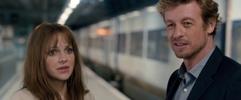 Movie still from “I Give It a Year” (2013), directed by Dan Mazer – A man and a woman standing in front of a train; Close Up shot, Over the shoulder angle