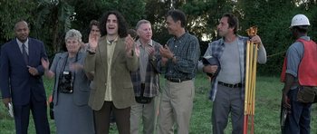 Movie still from “I Heart Huckabees” (2004), directed by David O. Russell – A group of men standing next to each other in the grass; Medium shot, Over the shoulder angle
