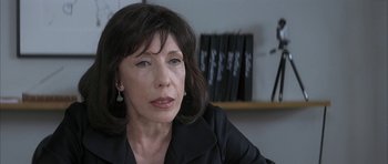 Movie still from “I Heart Huckabees” (2004), directed by David O. Russell – A person sitting in a room; Close Up shot, Over the shoulder angle