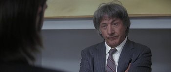 Movie still from “I Heart Huckabees” (2004), directed by David O. Russell – A person wearing a suit and tie; Close Up shot, Over the shoulder angle