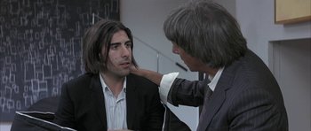 Movie still from “I Heart Huckabees” (2004), directed by David O. Russell – A man with long black hair and a man with long black hair; Medium shot, Over the shoulder angle
