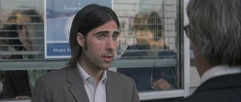 Movie still from “I Heart Huckabees” (2004), directed by David O. Russell – A man with long hair and a suit; Close Up shot, Over the shoulder angle