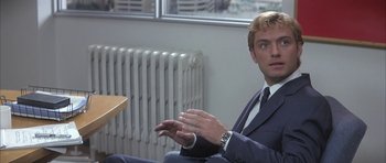 Movie still from “I Heart Huckabees” (2004), directed by David O. Russell – A man in a suit sitting in front of a window; Close Up shot, Over the shoulder angle