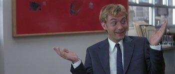 Movie still from “I Heart Huckabees” (2004), directed by David O. Russell – A man wearing a suit and tie holding out his hand; Close Up shot, Low angle