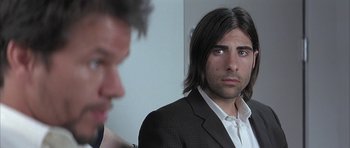 Movie still from “I Heart Huckabees” (2004), directed by David O. Russell – A man with long hair is looking at the camera; Close Up shot, Over the shoulder angle