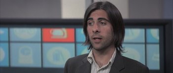 Movie still from “I Heart Huckabees” (2004), directed by David O. Russell – A man with long hair and wearing a suit; Close Up shot, Over the shoulder angle