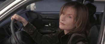 Movie still from “I Heart Huckabees” (2004), directed by David O. Russell – A woman sitting in the drivers seat of a car; Close Up shot, High angle