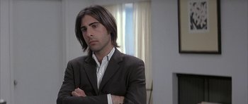 Movie still from “I Heart Huckabees” (2004), directed by David O. Russell – A man in a suit with his arms crossed; Close Up shot, Over the shoulder angle