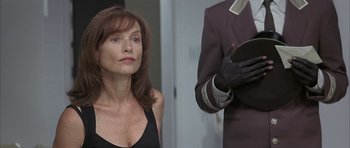 Movie still from “I Heart Huckabees” (2004), directed by David O. Russell – A woman standing next to a man in a suit; Close Up shot, Low angle