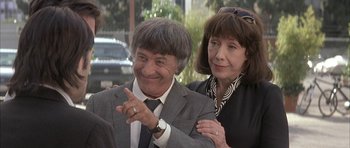 Movie still from “I Heart Huckabees” (2004), directed by David O. Russell – A man and a woman standing next to each other in front of a building; Medium shot, Over the shoulder angle