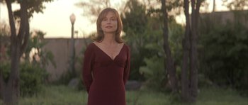 Movie still from “I Heart Huckabees” (2004), directed by David O. Russell – A woman in a red dress standing in the grass; Medium shot, Low angle