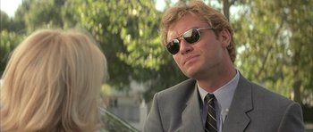 Movie still from “I Heart Huckabees” (2004), directed by David O. Russell – A man in a suit and sunglasses looking to his left; Close Up shot, Low angle
