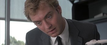 Movie still from “I Heart Huckabees” (2004), directed by David O. Russell – A person wearing a suit and tie; Close Up shot, Over the shoulder angle